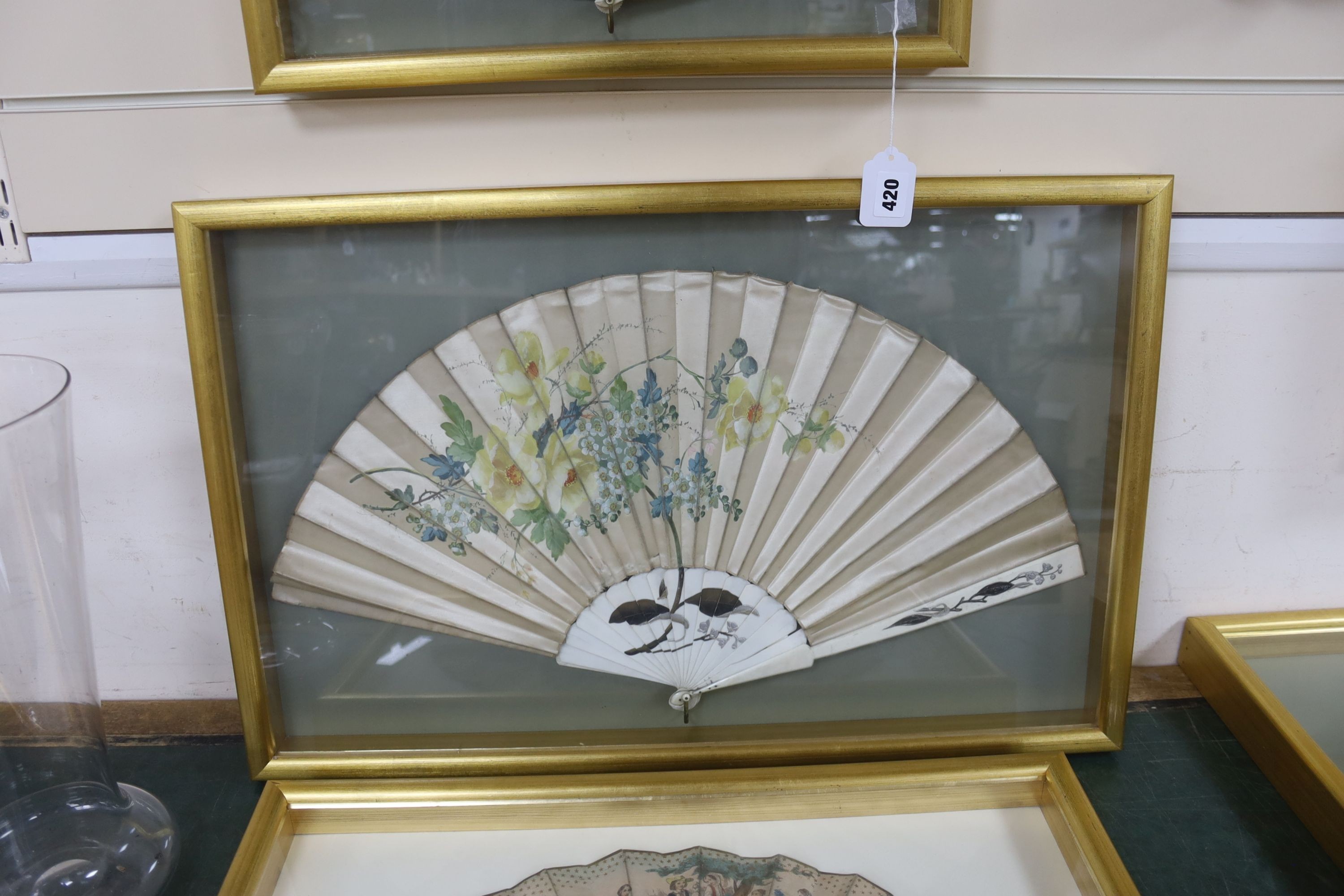 An early 19th century had tinted paper and ebony fan and two late 19th century ivory silk and bone fans, one painted with floral sprays, all three cased, largest case 46 x 71 cm (3)